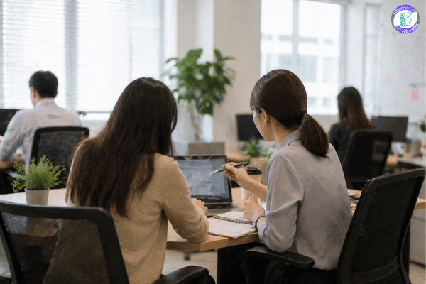 Người mới trao đổi công việc với đồng nghiệp trong văn phòng